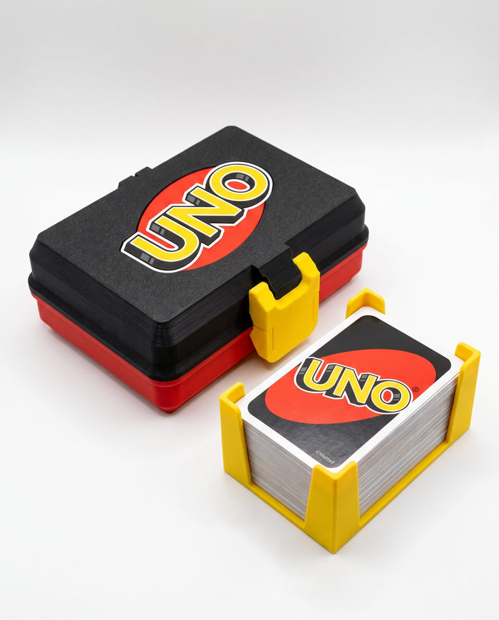 Caja de UNO abierta con el mazo sobre su soporte amarillo